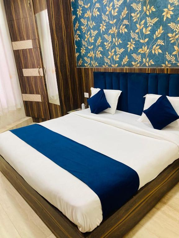 a large bed with blue and white sheets and pillows at Hotel SR Siddhivinayak Mathura in Mathura