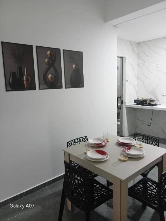 a dining room table with chairs and plates on it at Casa nova, completa, 3 quartos 1 com ar condicionado in Hortolândia