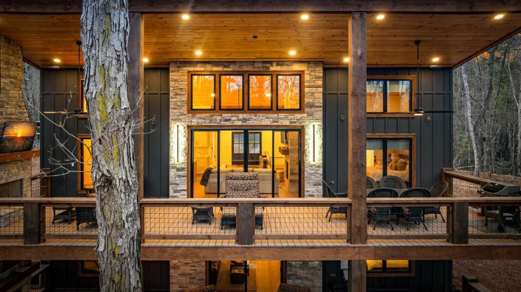 a home with a porch with chairs and a tree at Timber Haven in Blue Ridge
