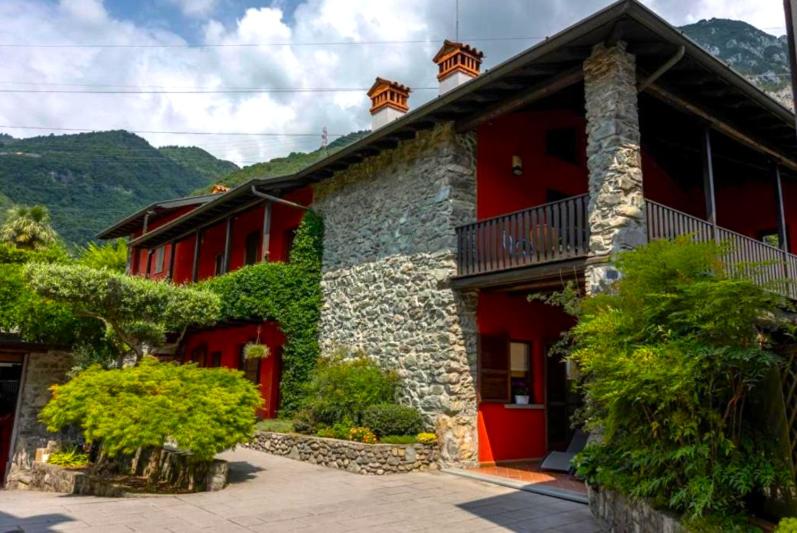 a red and stone building with a red door at Casa C'era una volta in Costa Volpino