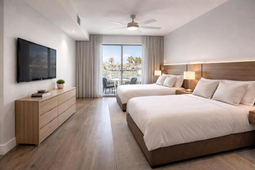 a hotel room with two beds and a flat screen tv at CW Hotel in Clearwater Beach