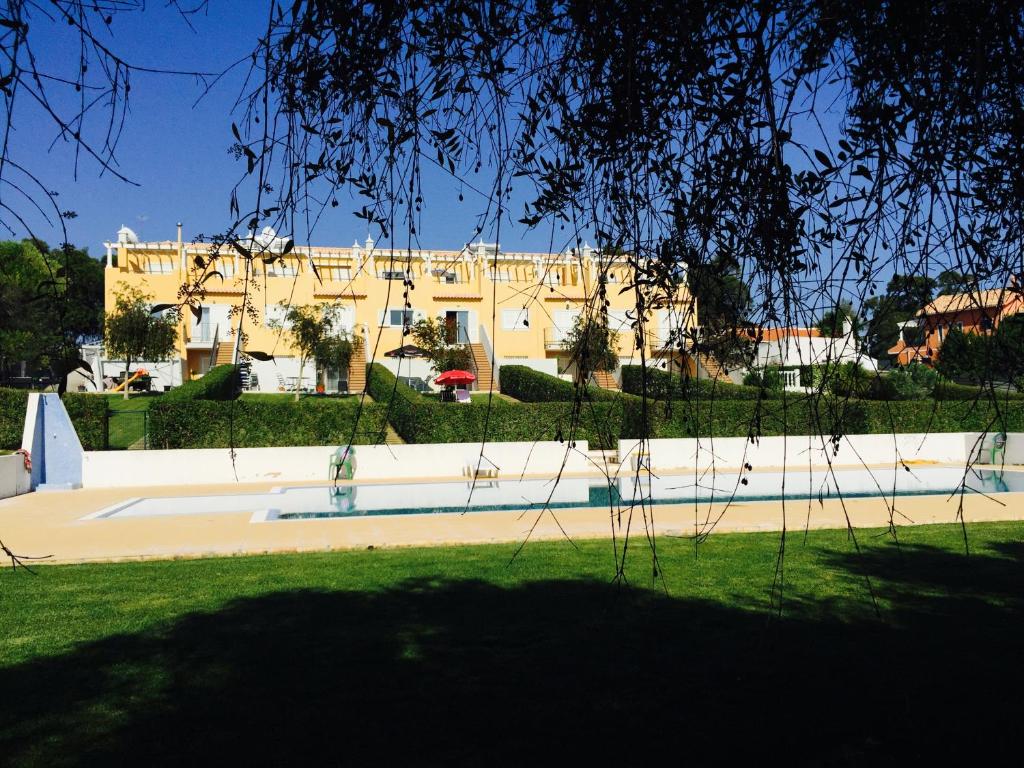 ein großes gelbes Gebäude inmitten eines Parks in der Unterkunft Albufeira Luxury Villa in Albufeira