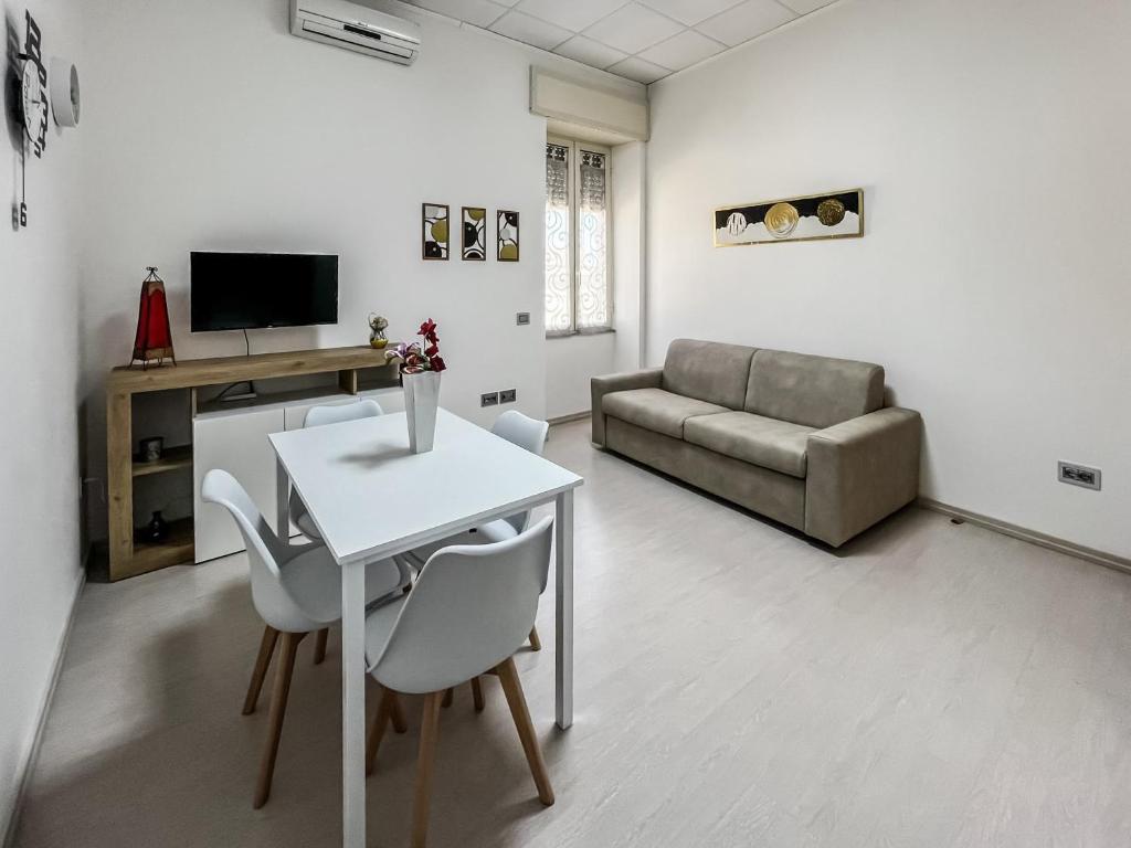 ein Wohnzimmer mit Tisch, Stühlen und Sofa in der Unterkunft Corte Dolia in Dolianova