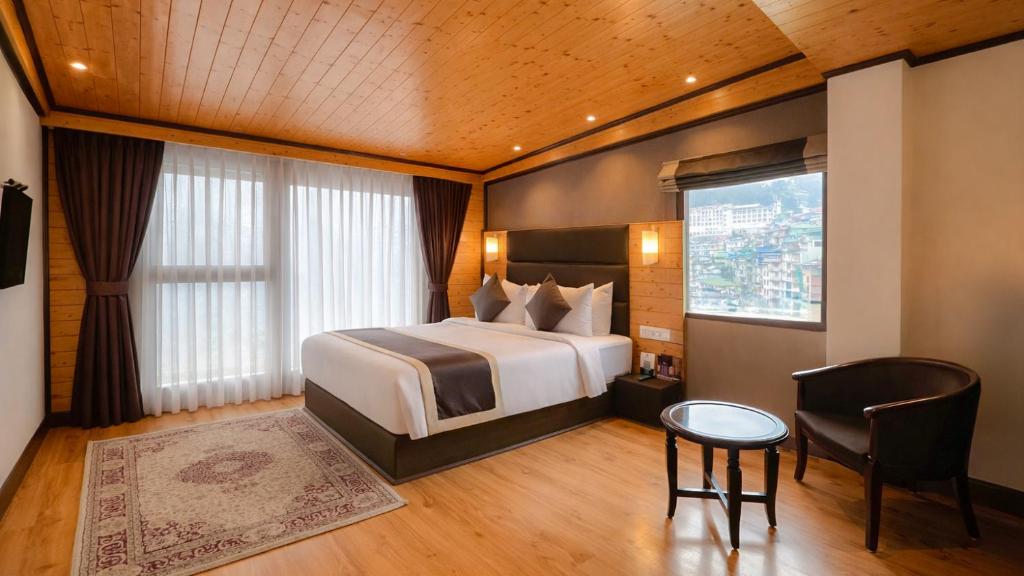 a hotel room with a bed and a table and a chair at Sumitel Shangrila in Tādong