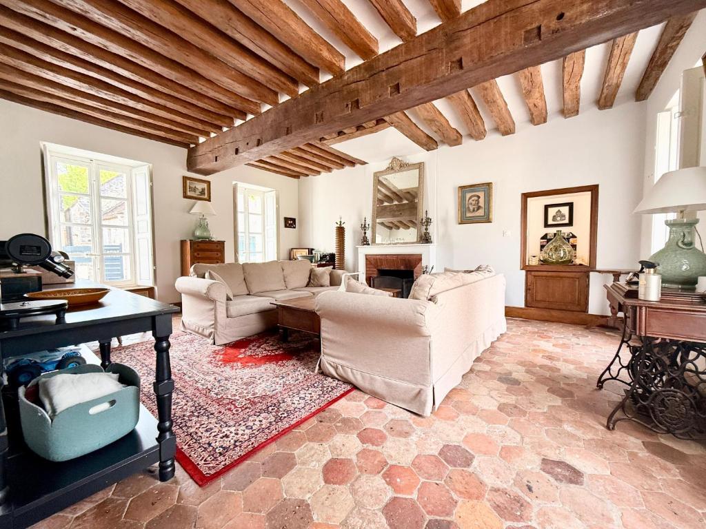 a living room with two couches and a piano at Former riverside rectory in Nanteau-sur-Lunain