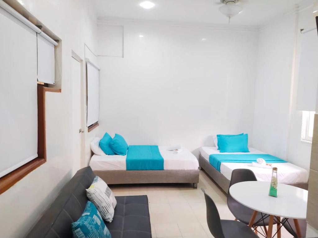 a small room with two beds and a table at comodo alojamiento centro Histotico cartagena - 3 in Cartagena de Indias