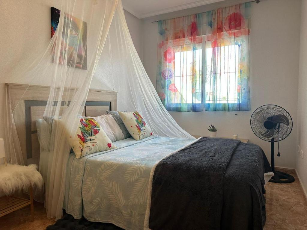 a bedroom with a bed with a mosquito net at BEACH AND CHILL APARTMENT con encanto in Los Alcázares