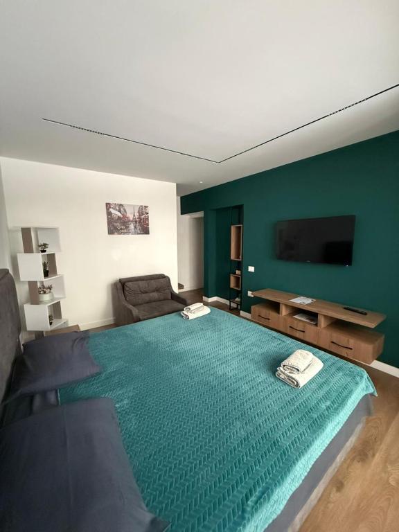 a living room with a large green bed with a couch at Downtown Apartment Rooms in Tirana