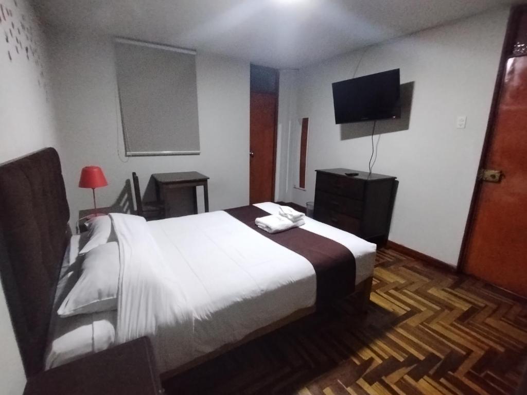 a bedroom with a bed and a flat screen tv at MNk HOTEL in Arequipa
