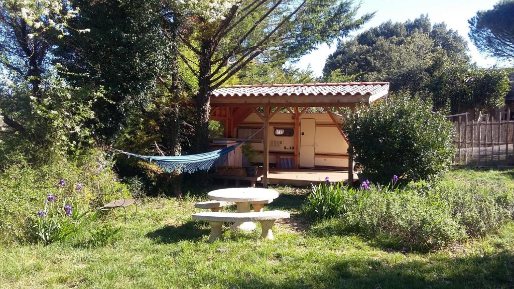 a picnic table in a yard with a shed at Ô Grézac in Lodève