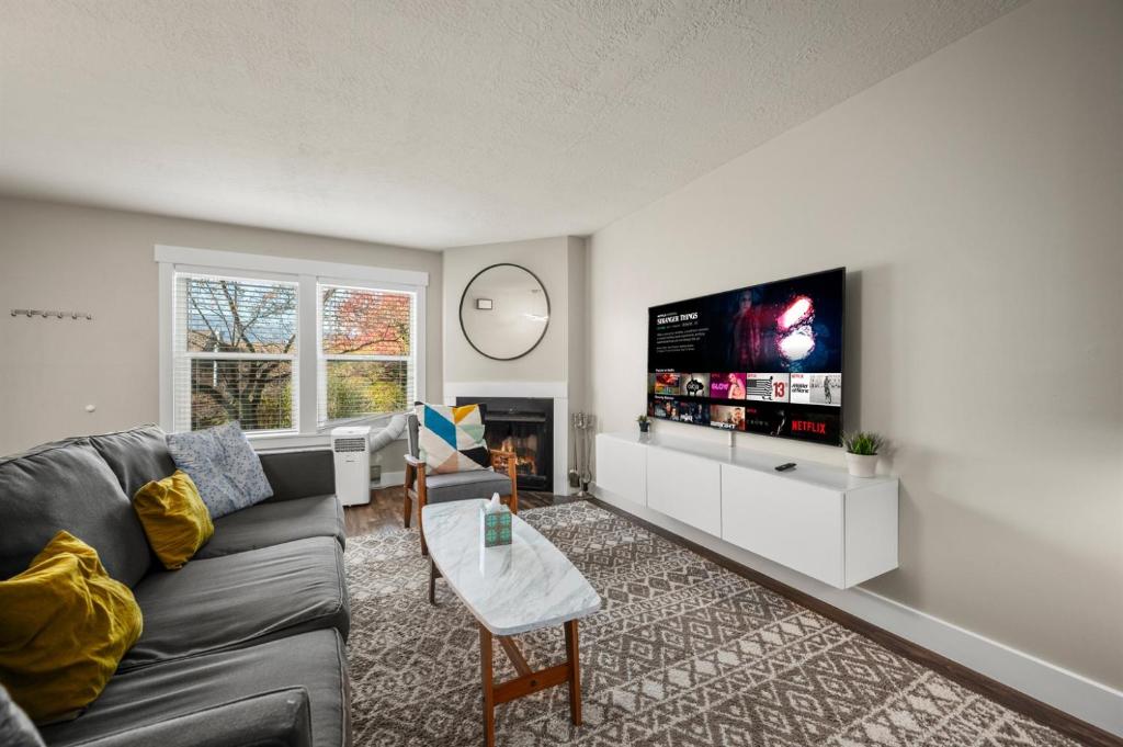 a living room with a couch and a flat screen tv at Powder Peak Hideaway WL203 Ski Escape Hot Tub in Eden