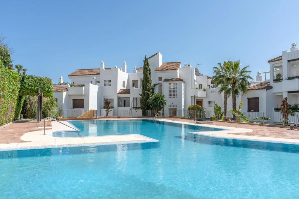 a large swimming pool in front of some buildings at Spacious 6-bed Apartment in Marina de la Alcaidesa in La Alcaidesa