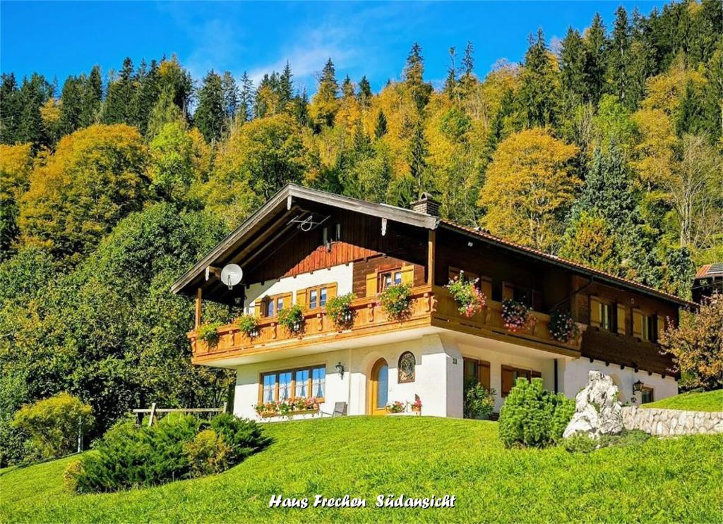 ein Haus auf einem Hügel mit Bäumen in der Unterkunft Haus Frechen in Berchtesgaden