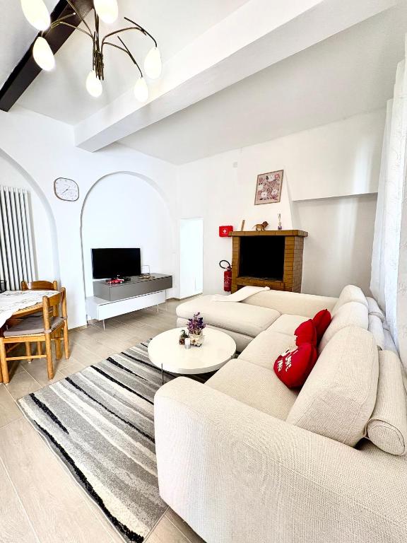 a living room with a white couch and red pillows at Casa in Centro con Giardino in Imola
