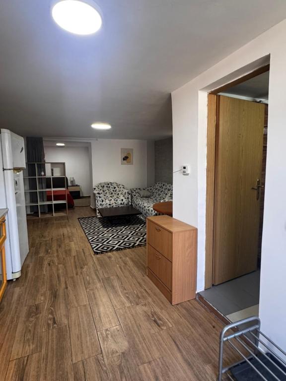 a living room with a couch and a wooden floor at Studio Park in Craiova