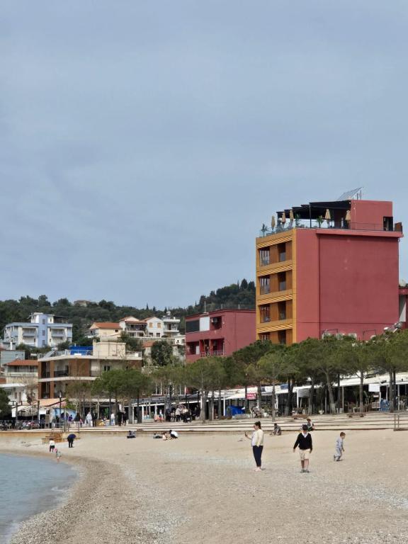 a group of people walking on the beach at Hotel Veizi in Himare