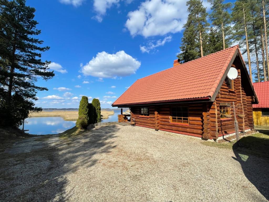 a log cabin with a red roof at Oksa Puhkemaja in Võru