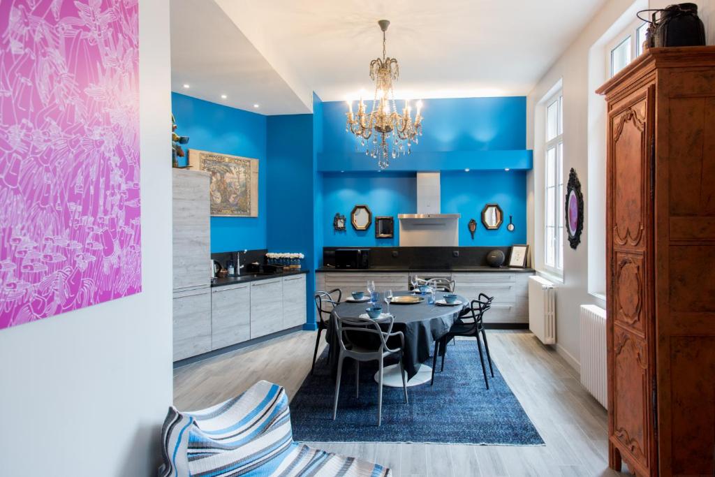 a dining room with blue walls and a table and chairs at Le Blue Note intra-muros - Bel appartement de standing in Saint Malo