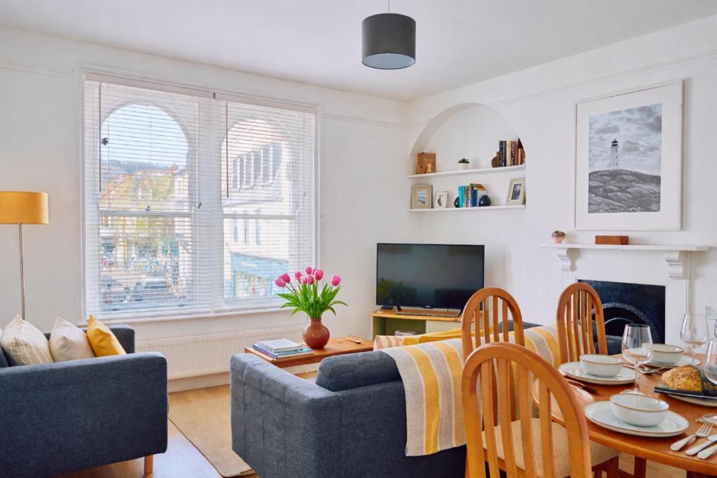 a living room with a blue couch and a table at Finest Retreats - Centre View in Sidmouth