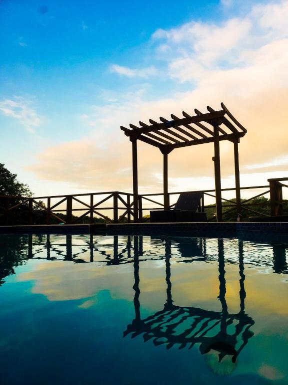 a swimming pool with a wooden pergola and water at Careffe Escape Hideaway in Monchy