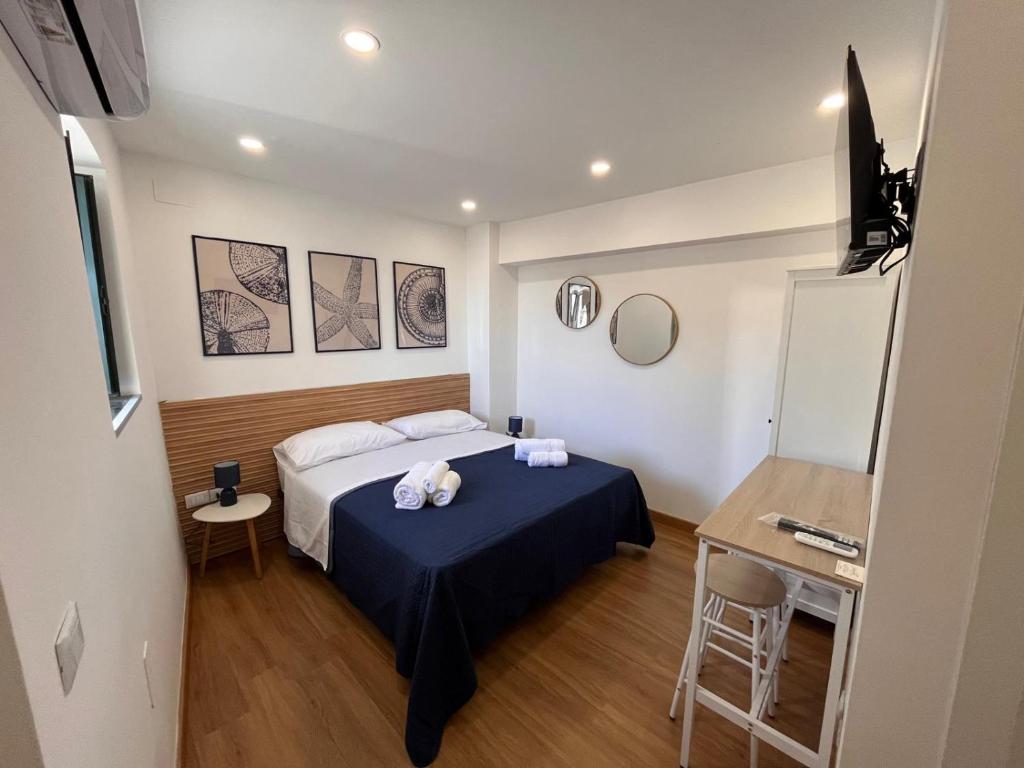 ein Schlafzimmer mit einem Bett, einem Tisch und einem Schreibtisch in der Unterkunft Ondablurooms2 in Pizzo