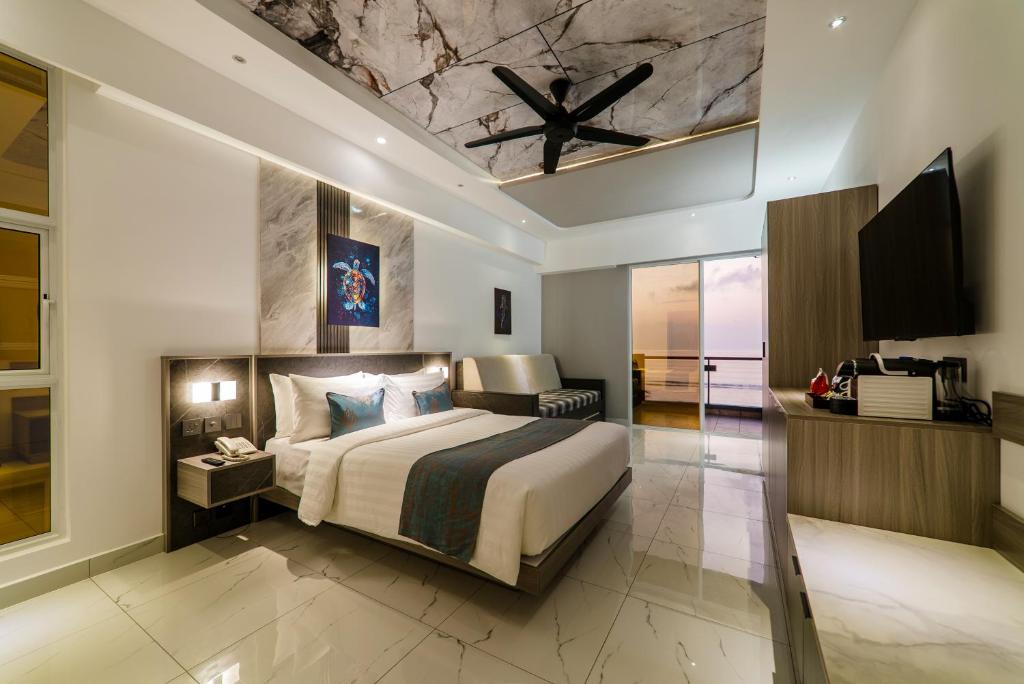 a bedroom with a king sized bed and a television at Samann Blue in Hulhumale