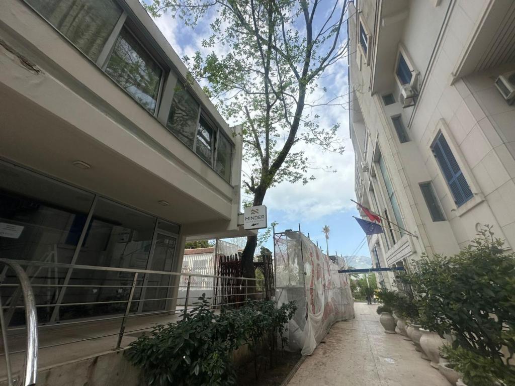 an empty alley next to a building with a tree at Old Town Apart in Budva