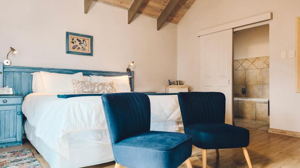 a bedroom with a bed and a blue chair at Baywatch Guest House in Paternoster