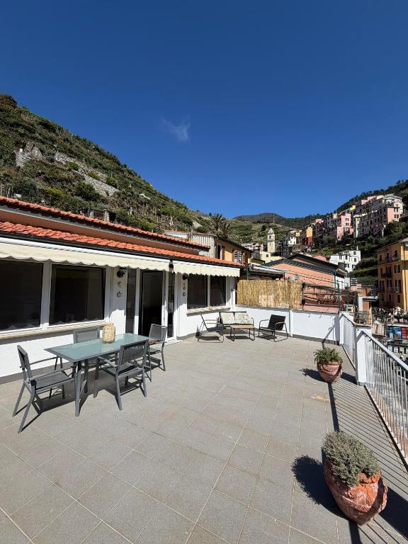 a patio with a table and chairs on a roof at Terrazza in Manarola