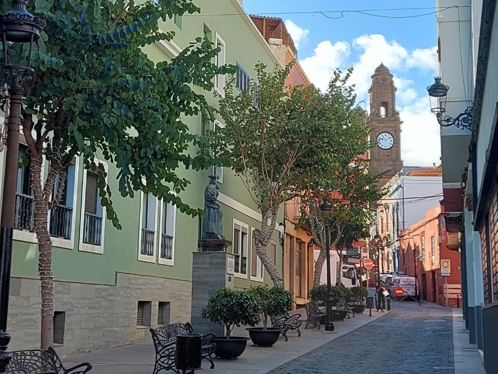 a city street with a clock tower in the distance at Gáldar-Centro in Gáldar