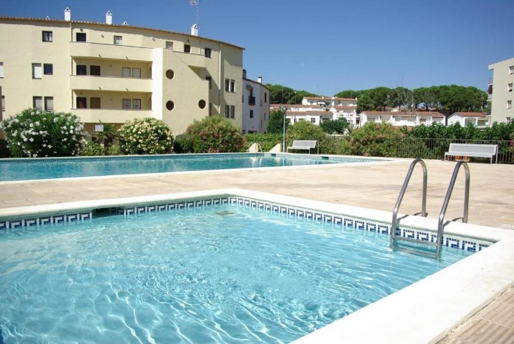 a swimming pool in front of a building at Apartamento luminoso a 100mts playa, ambiente tranquilo in L'Escala