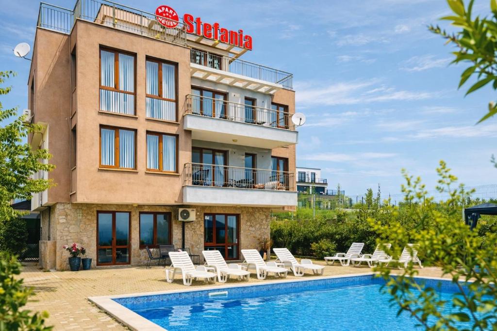 a hotel with a swimming pool in front of a building at Stefaniya Apartments in Sozopol