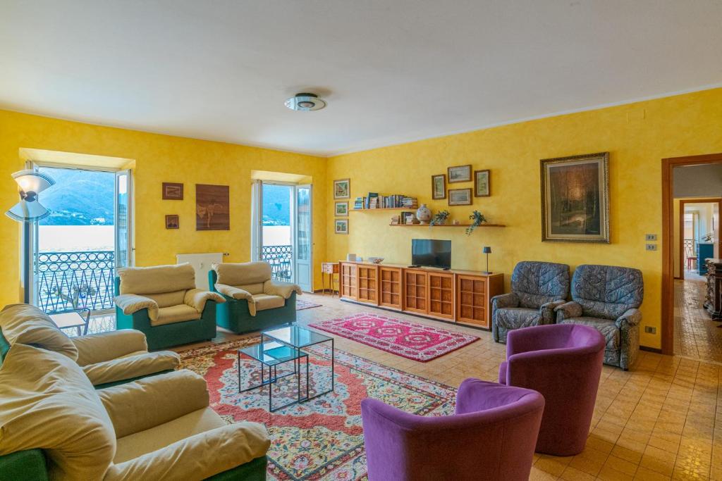 a living room with couches and chairs and a television at GuestHost - Lovely Lakeview Flat in Central Dongo in Dongo