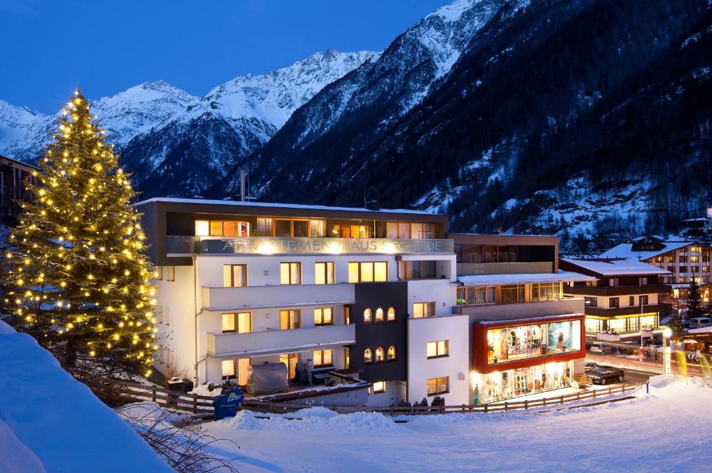 ein Hotel mit einem Weihnachtsbaum vor einem Berg in der Unterkunft Appartementhaus Sieglinde in Sölden