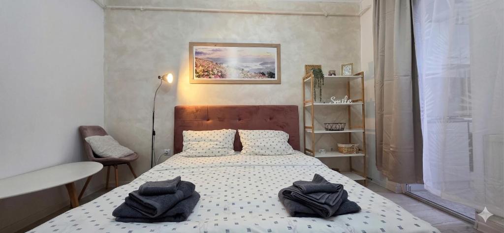 a bedroom with a bed with black towels on it at Single room Perfect for couples or singles in Roşu