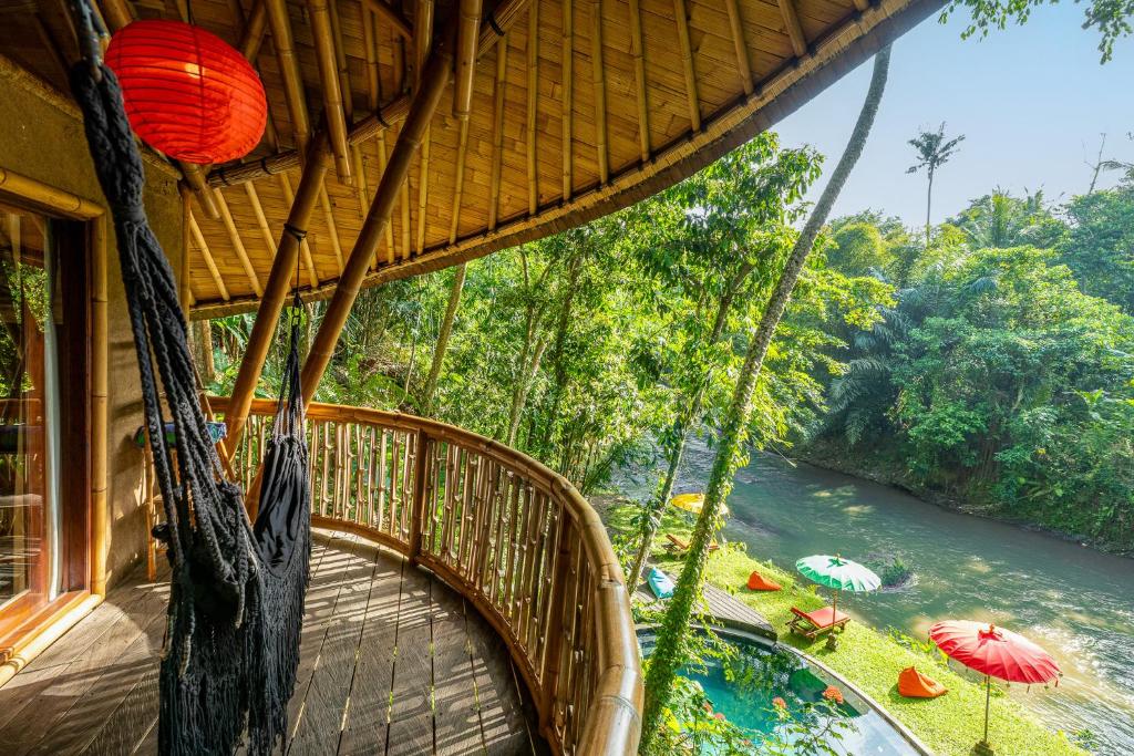 a room with a swinging bridge and a river at Bamboo Turtles Ecolodge in Ubud
