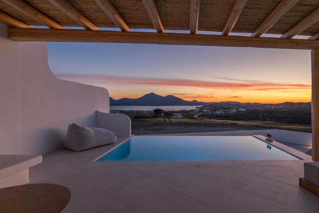 a villa with a swimming pool and a sunset at Villa Leuki in Adamantas