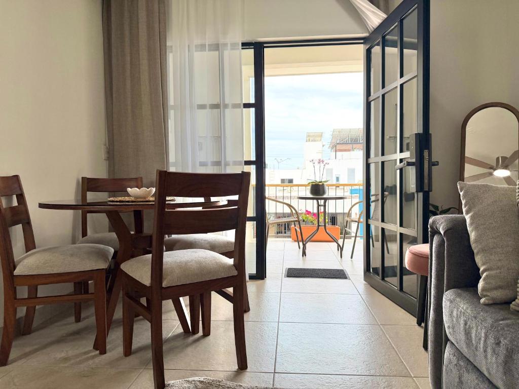 a living room with a table and chairs and a balcony at Casa DOS21 Boutique Apartments Playa Sur in Mazatlán