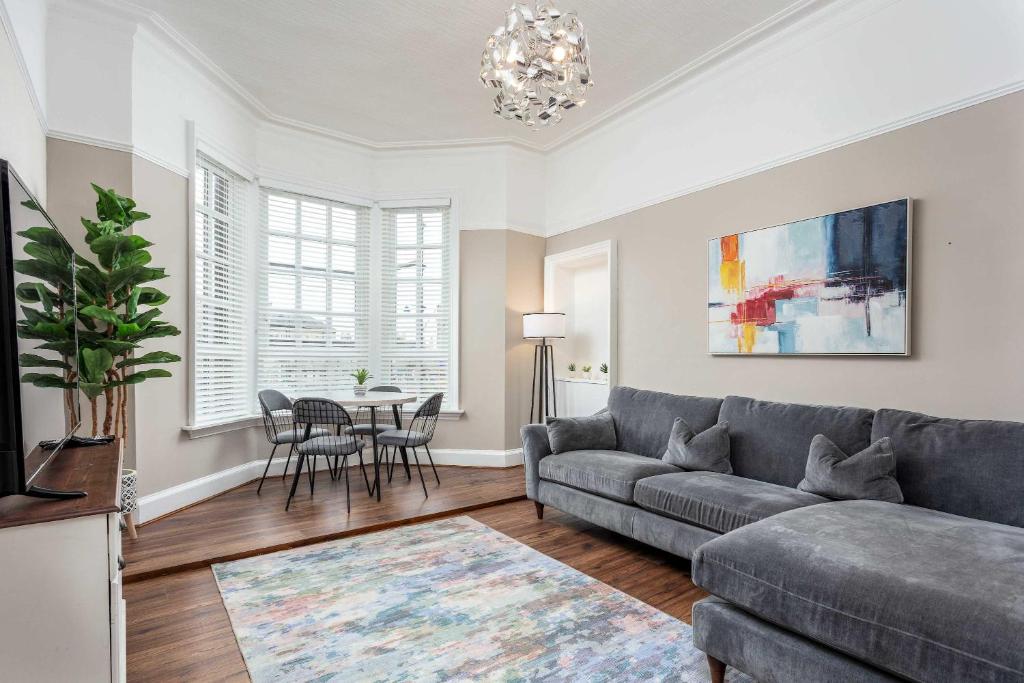 a living room with a couch and a table at Main Street View - Donnini Apartments in Prestwick