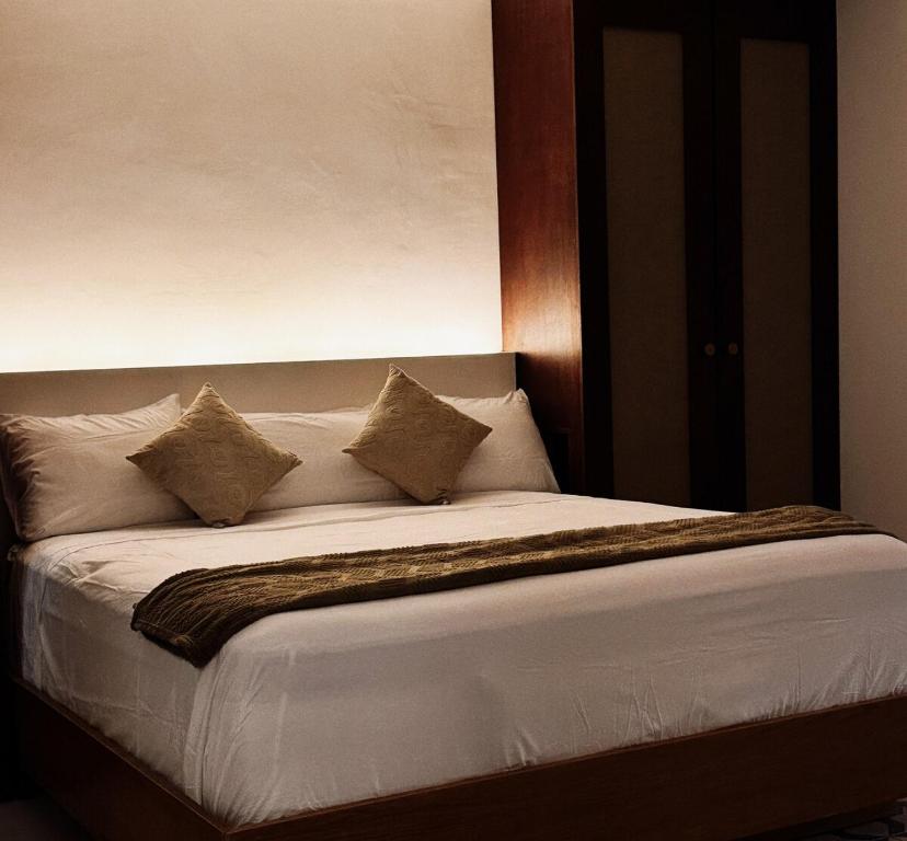 a bed with four pillows on top of it at Casa San Martín, Campeche #2 in Campeche