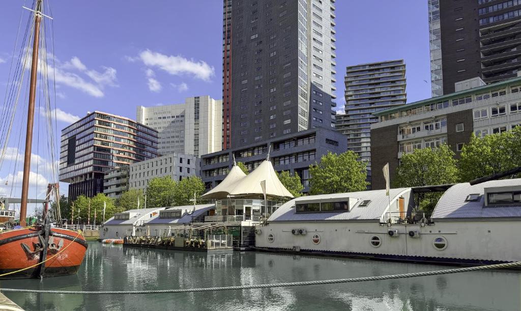 eine Gruppe von Booten, die in einer Stadt im Wasser vor Anker liegen. in der Unterkunft FLOATS by H2OTEL Rotterdam in Rotterdam