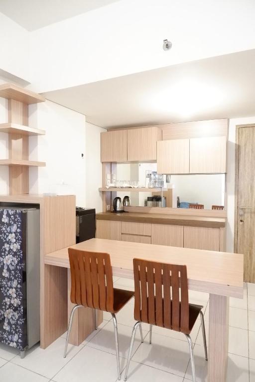 a kitchen with a wooden table and two chairs at apartment candiland room 45 m2 in Jomblang