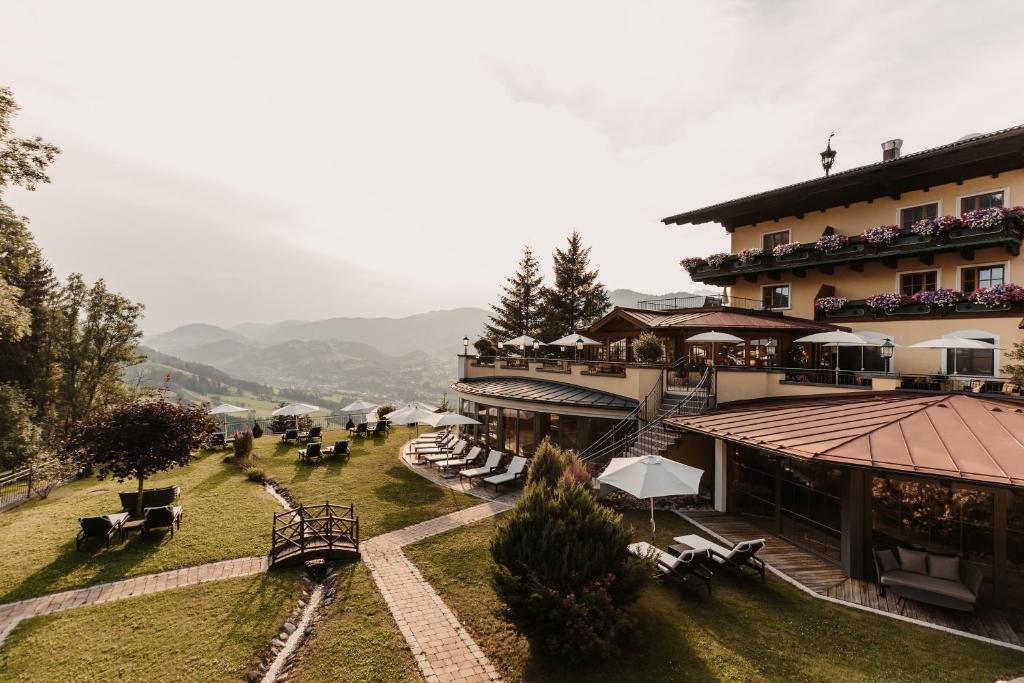 a hotel with chairs and tables in front of a building at Gut Berg Naturhotel in Sankt Johann im Pongau