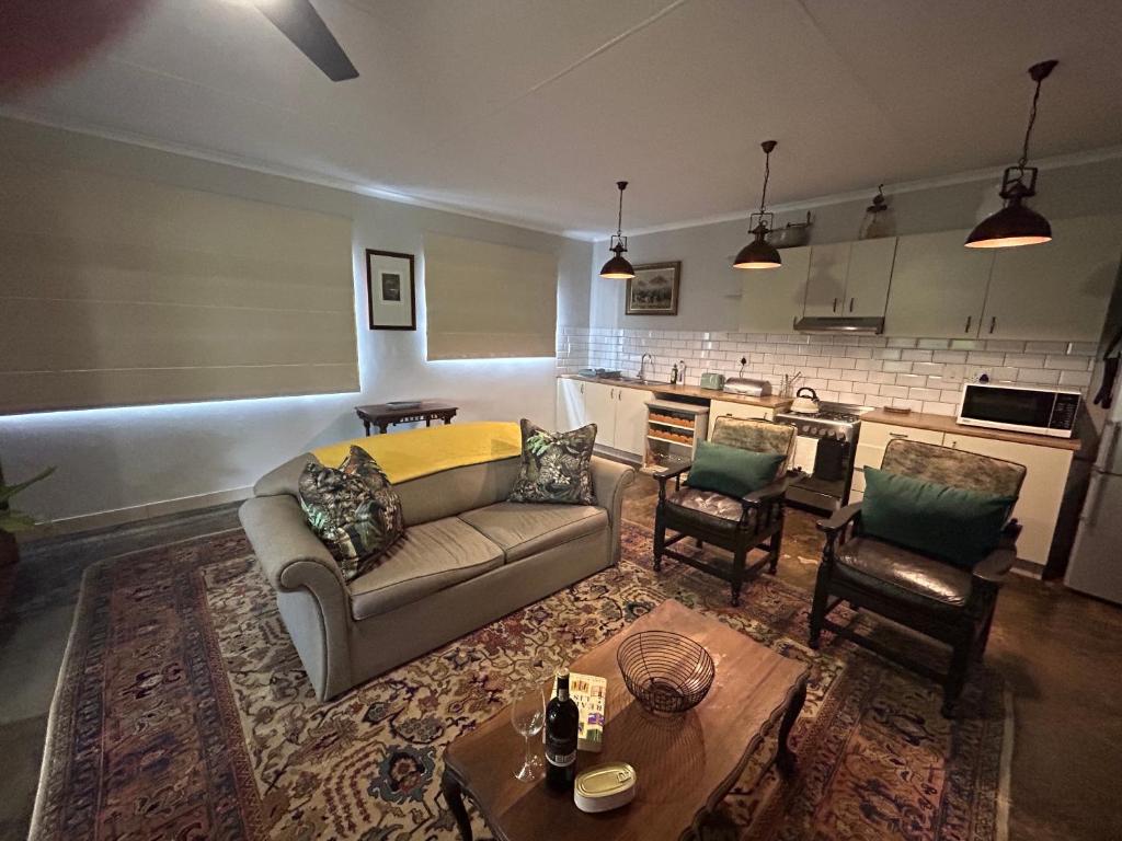 a living room with a couch and a table at Cedara Way Cottage in Hilton