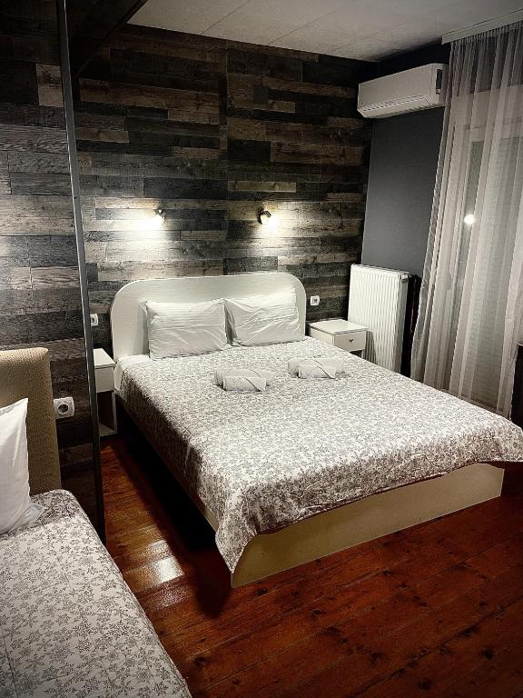 a bedroom with a bed and a wooden wall at Casablanca City Center Private Parking in Niš