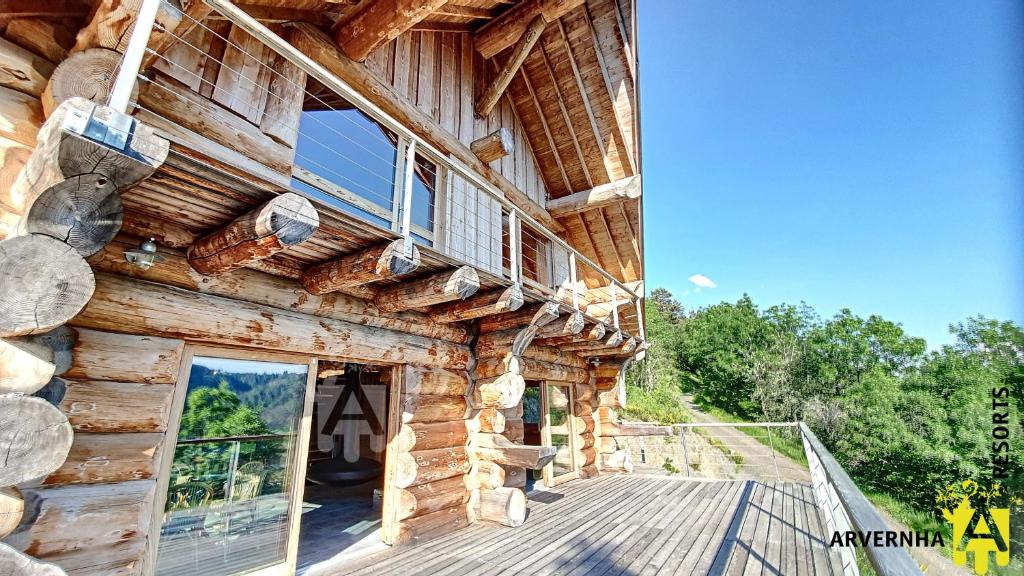 a log cabin with a porch and a balcony at Chalet Trappeur 8 Personnes in Beaune