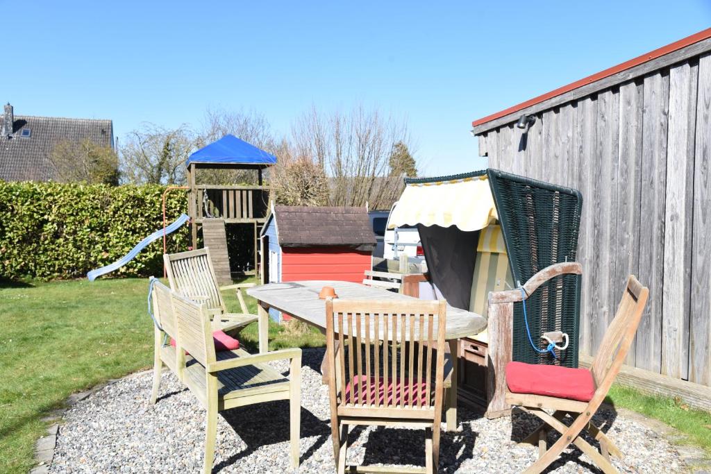a group of chairs and a table in a yard at Ferienwohnung Ankerpladsen Jolle in Behrensdorf