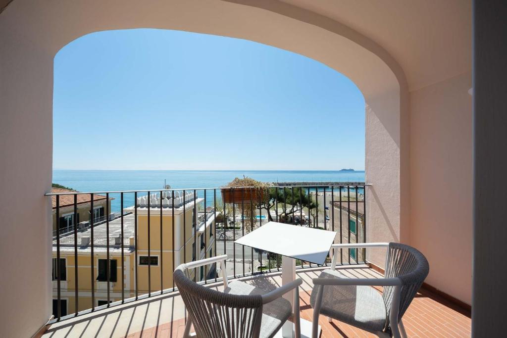 a balcony with a table and chairs and the ocean at San Francesco Amalfi Coast Hotel in Maiori