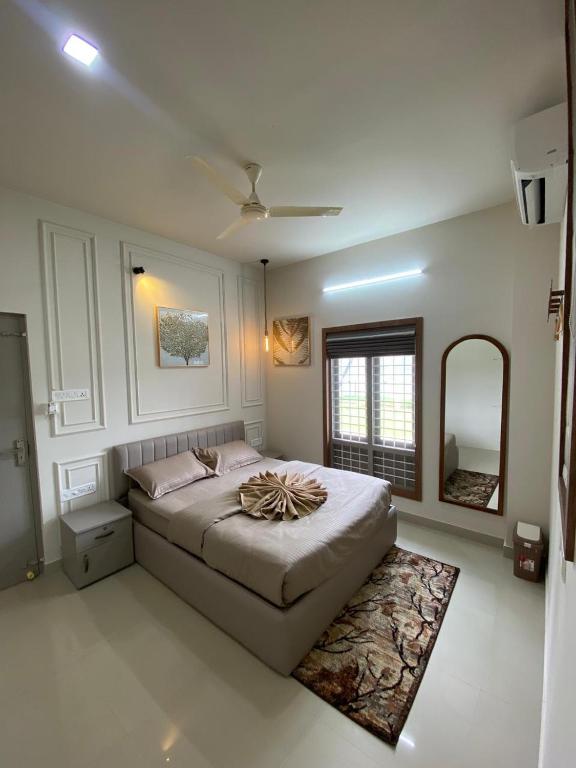 a bedroom with a large bed and a mirror at Riveria By Vstays in Kozhikode