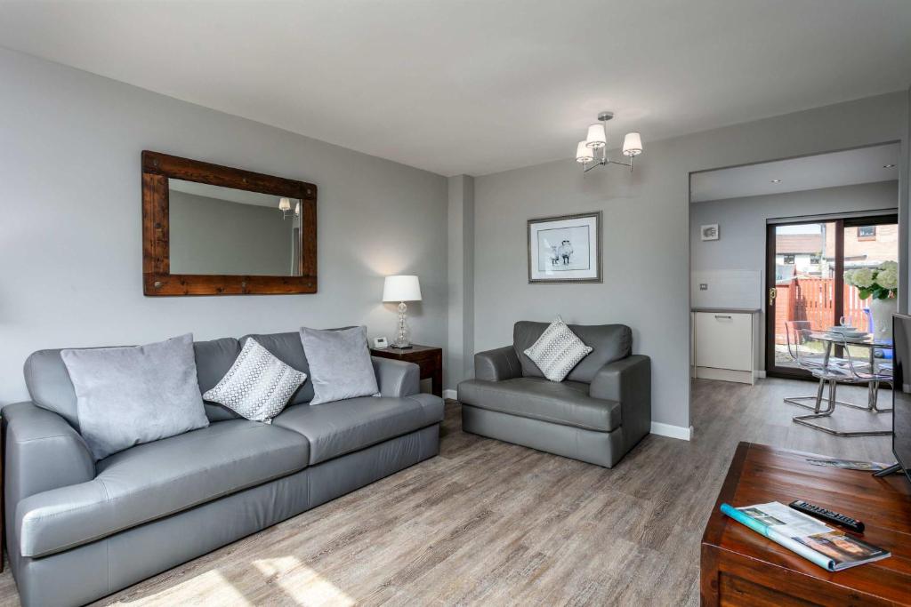 a living room with a couch and a chair at The Huntington - Donnini Apartments in Ayr